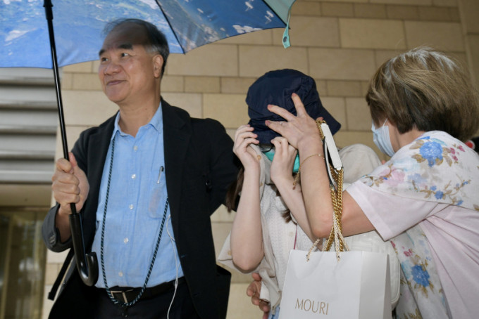 被告袁靜婷保釋獲批後，由家人陪同離開法院。 梁譽東攝