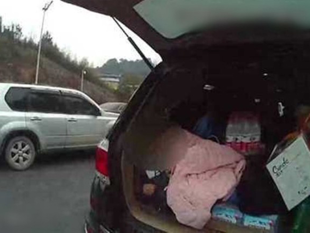 民警打开车尾箱发现有一名孩童睡在里面。 网图