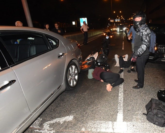 西环有电单车撞私家车，司机及女乘客倒地。