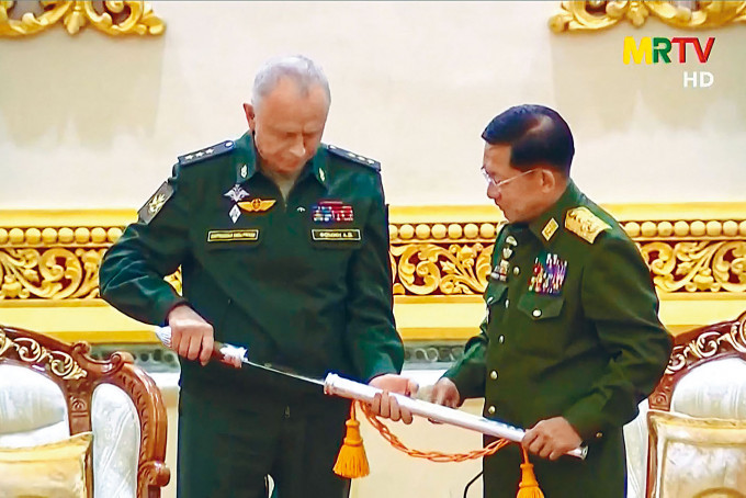 ■俄副國防部長福明（左）獲敏昂萊贈送一把禮儀佩劍。