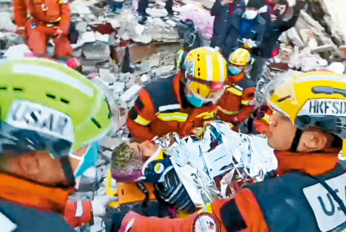 特区救援队挖出救援通道，从瓦砾中救出一名女生还者。 