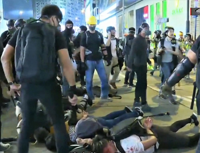 当晚有疑为警员的黑衣人持警棍拘捕示威者。