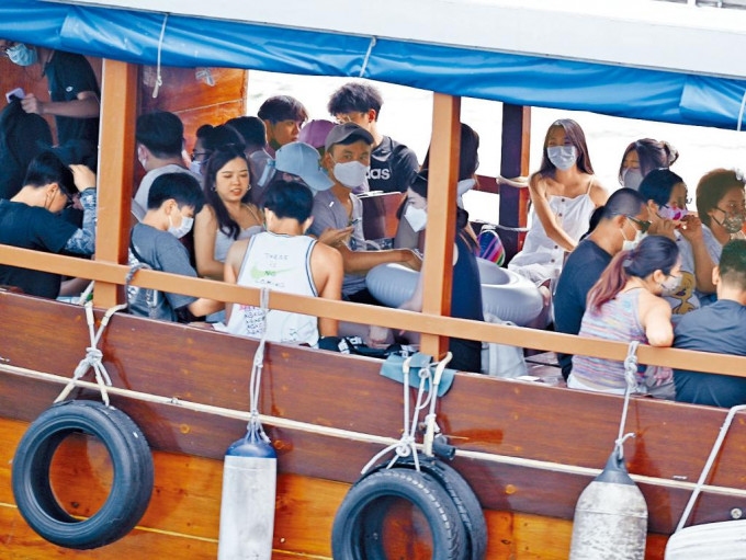 在西贡码头，大批市民乘船出海吹海风玩乐。
