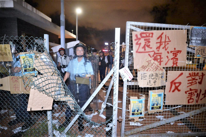示威者一度剪开围栏铁丝网。