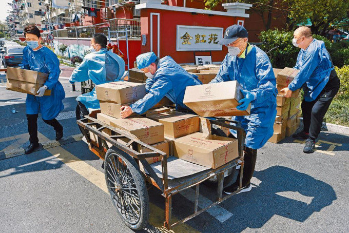 上海工作人员在小区门口运送生活物资。
