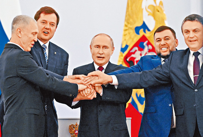 普京在克宫签署文件后，与顿涅茨克、卢甘斯克、赫尔松和扎波罗热四区首长手叠手合照。