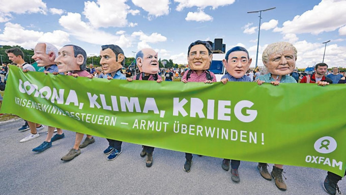 乐施会示威者在慕尼黑戴G7领袖面具抗议。