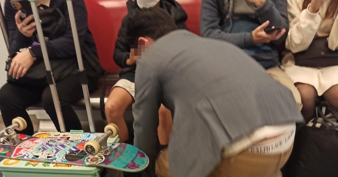 8歲童搭港鐵沉迷玩手機，甚至要爸爸蹲下來為他綁鞋帶。FB圖片