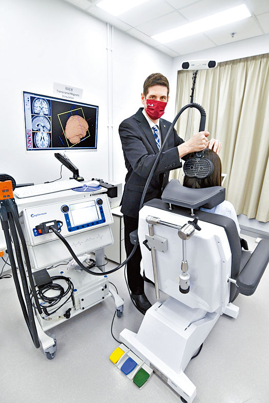 中心設有多部儀器，讓團隊研究眼疾病人和治療方法。圖為Ben Thompson示範使用「腦磁波」儀器。