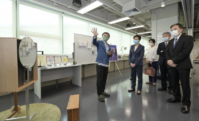 行政长官林郑月娥（左二）听取该校研发的「便携式互动与冥想镜」的介绍。政府新闻处