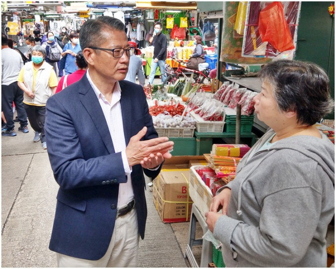 陈茂波（左）到街市、排档和茶餐厅与市民聊天，听他们对《预算案》的意见。