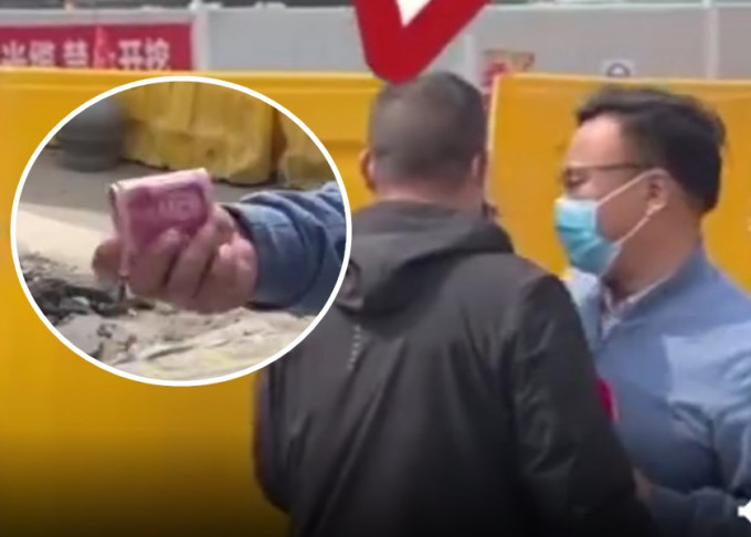 河南记者采访地盘事故期间，疑被工作人员拉扯及塞入现金。影片截图
