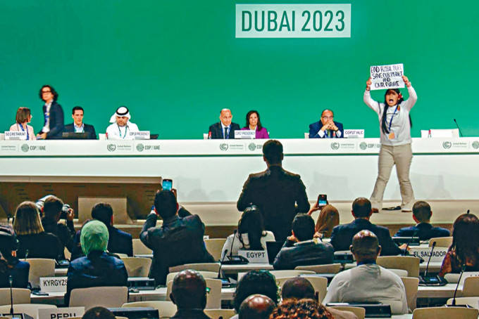 12岁印度女示威者坎古贾姆，周一高举写上「结束化石燃料，拯救我们的地球和未来」的标语，冲上杜拜COP28气候大会的讲台。