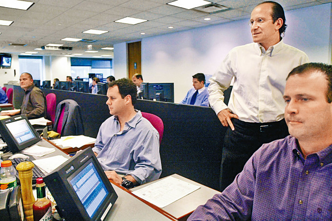 ■卢特尼克(后右一)二○○二年在纽约办公室察看交易员工作。