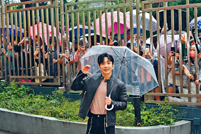 Anson Lo離開電台時特別走近圍欄，與冒雨守候的粉絲打招呼及合照。