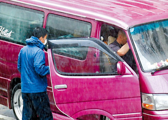 林海峰（左）冒雨跟坐在司机位的葛民辉商讨细节。