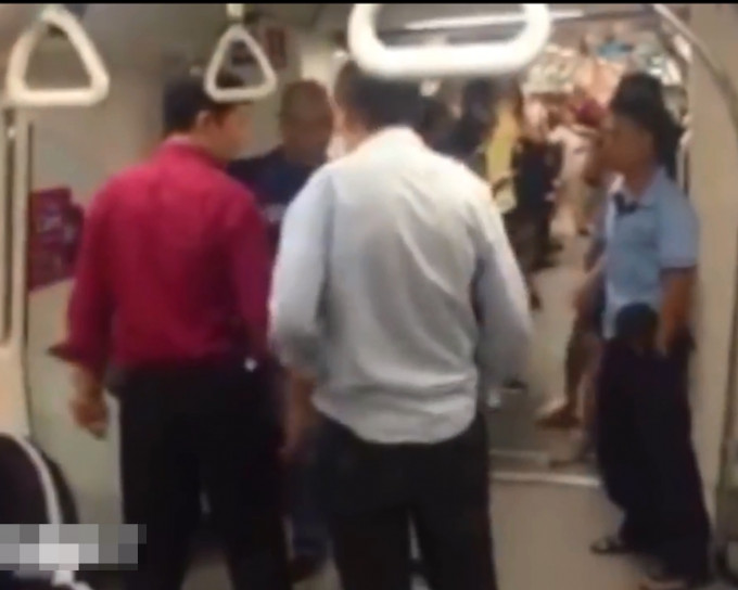 在地铁人员(红衣)的劝解下，骂人者(浅蓝恤衫)最终被带走。片段截图