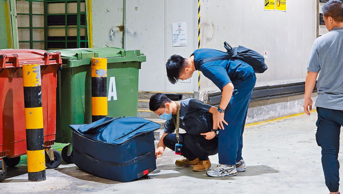探員小心翼翼檢查可疑行李箱。