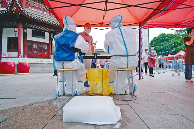 上海高溫，防疫工作人員在身邊放冰塊降溫。
