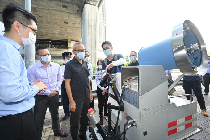 徐德義（左三）聽取機電工程署人員介紹試用中的大型機械超低微量噴灑器。政府新聞處圖片