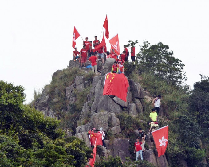 市民持旗登山，在山頂揮舞國旗及香港區旗。