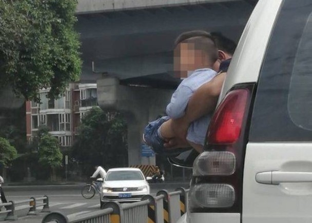 一名男子將尿急的男孩抱出車窗外解決。（網圖）