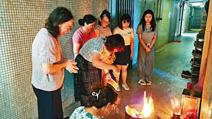 死者刘浩祥的妻子及两名女儿在寓所外拜祭。