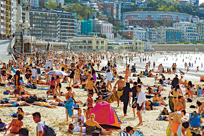 西班牙孔查海滩三月底挤满享受阳光的泳客。
