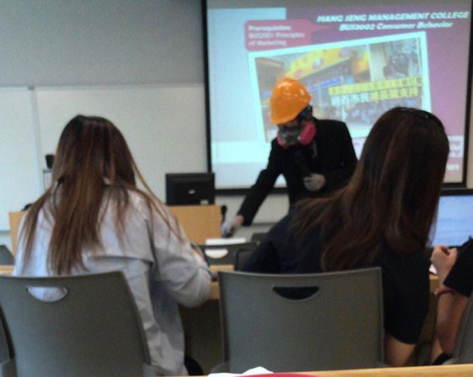 該名教師身穿黑衣，戴上頭盔和「豬嘴」口罩上課。網民Caidy Ng