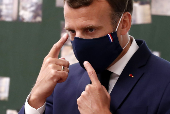 法國總統馬克龍日前戴上的一款法國製造的口罩到訪小學。 AP