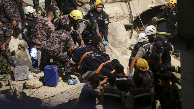 救援人員從瓦礫堆中救出最少一名女子。AP