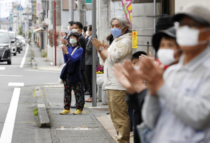 日本市民为抗疫的医护鼓掌。AP图