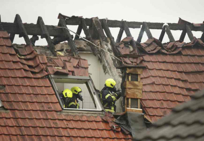 小型機撞落民房屋頂後引起火警。AP