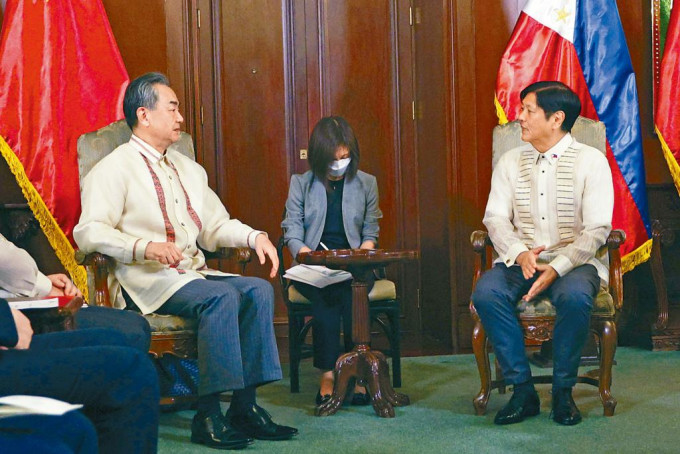 王毅（左）在马尼拉同菲律宾总统小马可斯会面。