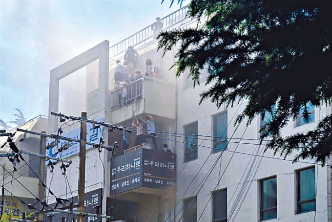 大邱市起火的辦公大樓有人群在陽台上等待救援。