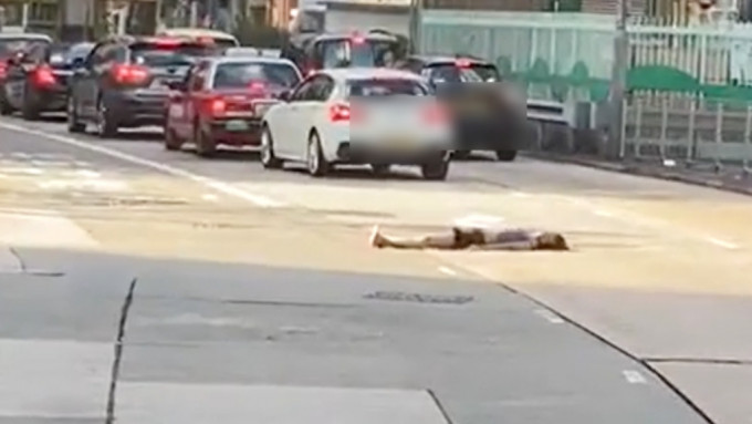 一名女子卧在荔枝角道马路中间，险象环生。影片截图