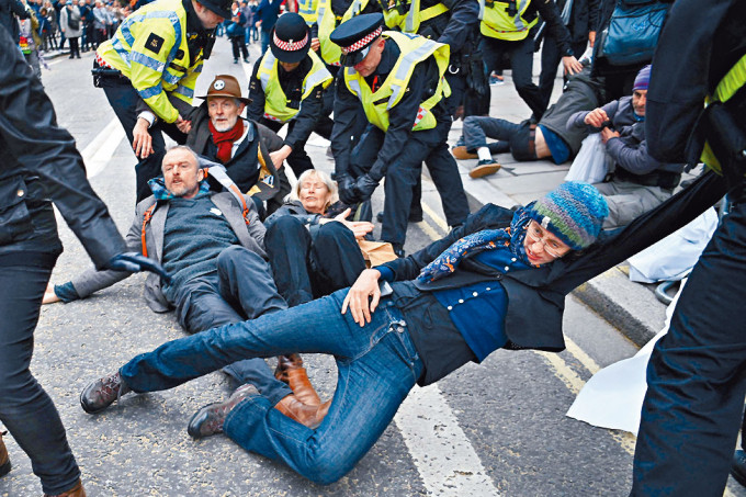 ■倫敦昨日有抗議氣候暖化的環保團體成員被警員拖走。