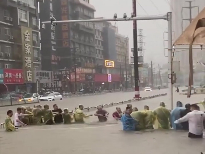 郑州市民组人链拉出地下被困者。网图