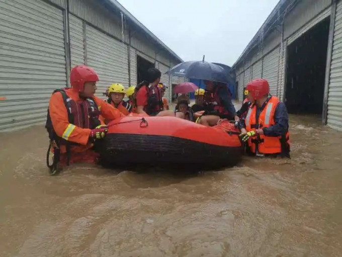 救援人員到場救出被水圍困的村民。網圖