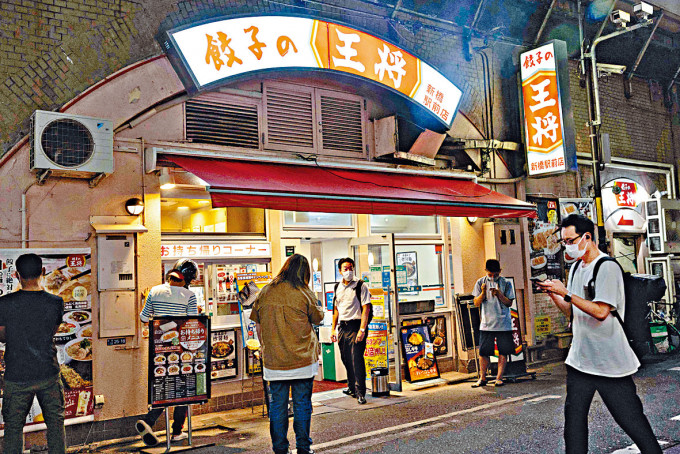 在秋葉原一家餃子店外，顧客保持距離等候取餐。