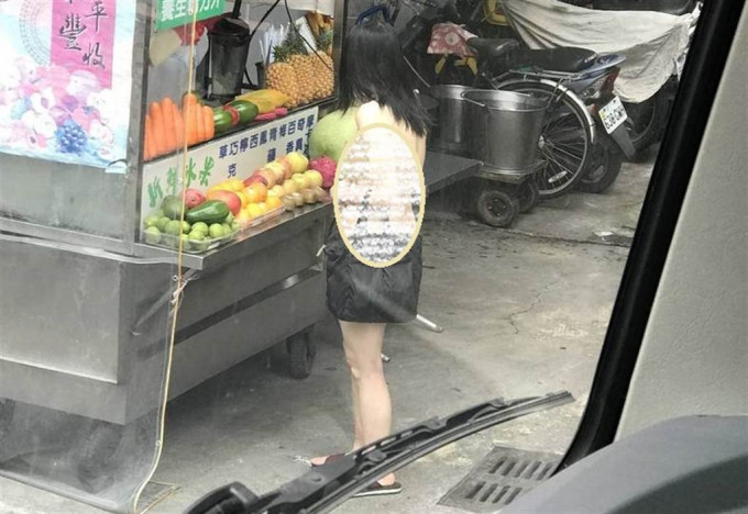 女子手持一杯木瓜牛奶在街上大搖大擺逛街。中時