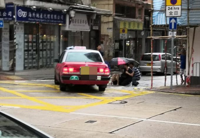 有熱心途人為傷者撐傘擋雨。 香港突發事故報料區FB/網民Silas Siu圖