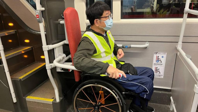 香港复康力量董事伍强试用新的扶手，认为新设施可以保护轮椅乘客。九巴图片