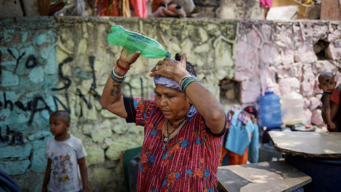 新德里一名女子用水淋头降温。 路透社