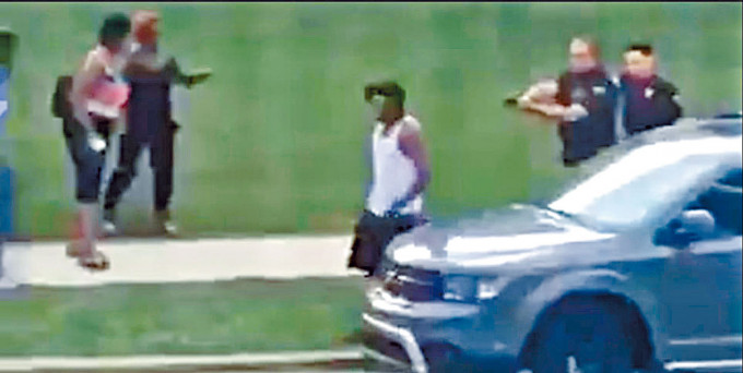 威斯康辛州非裔男子布莱克周日走向一辆汽车时，两名警察举枪跟在他后面。　