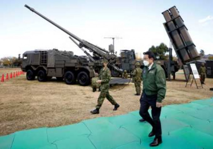 日相岸田文雄去年11月在朝霞训练场，步过19式自走炮(左)及12式地对舰导弹(右)。路透社