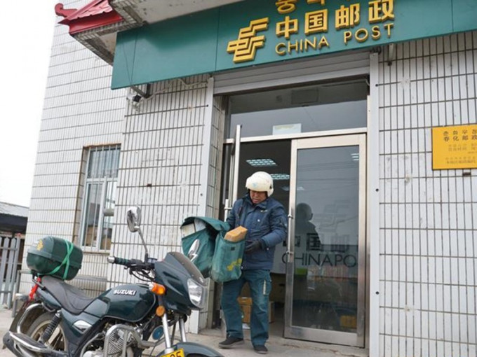 今年53歲的金仁哲，早在十一年前已經升職為春化支局的局長，但由於人手不夠，因此仍然每天跑村屯投遞。  新華社圖片