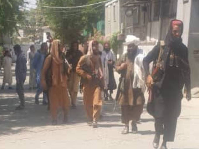 塔利班武裝份子進入喀布爾一間傳媒大樓檢查保安武器。網上圖片