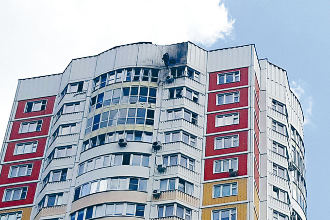 莫斯科一幢住宅大樓周二被跌落的無人機擊中受損，調查人員到場察看。