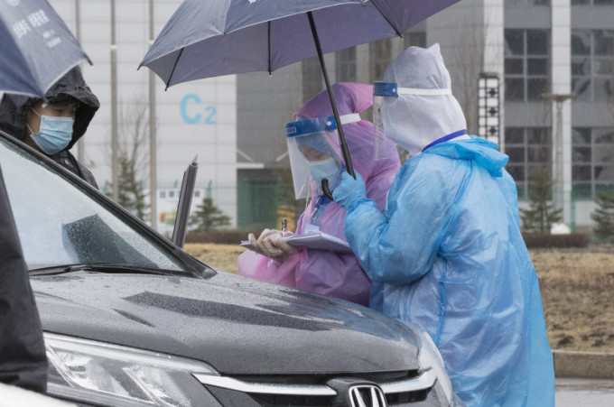 在黑龙江省绥芬河市，防疫工作者在雨中坚守岗位。（新华社图片）